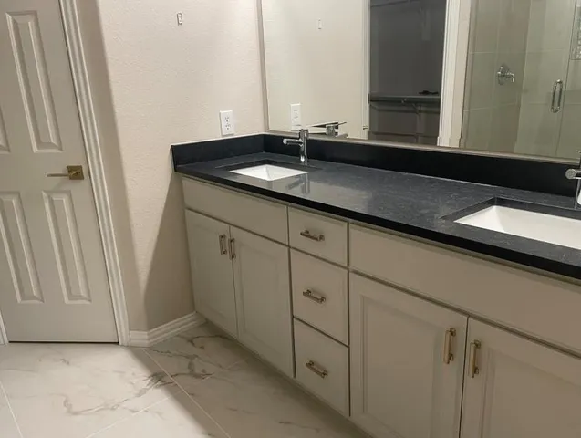 a bathroom with a granite countertop sink and a mirror