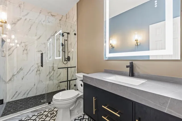 a bathroom with a sink a toilet and shower