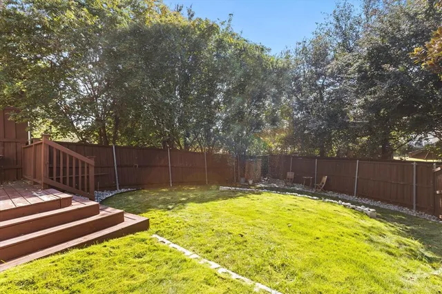 a view of a backyard with a small pool and wooden bench