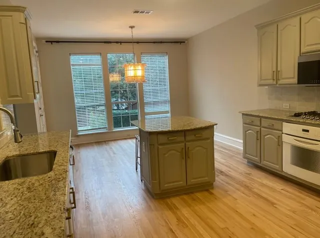 a kitchen with wooden floors and large window