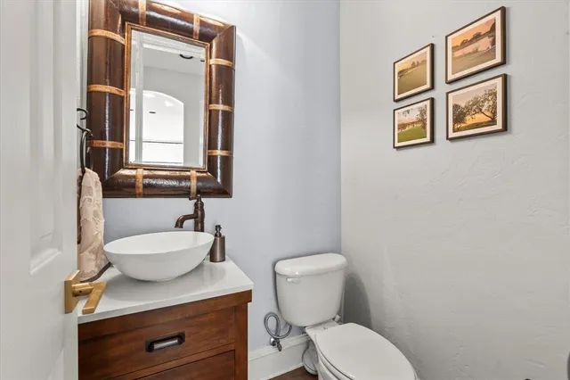 a bathroom with a granite countertop toilet sink and mirror
