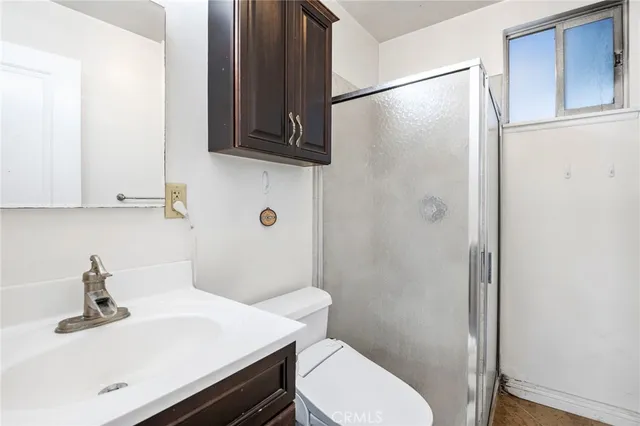 a bathroom with a sink a toilet and shower