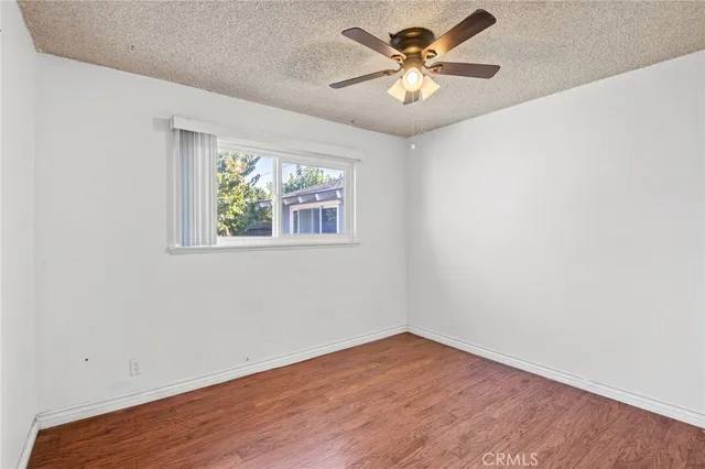 an empty room with wooden floor and window