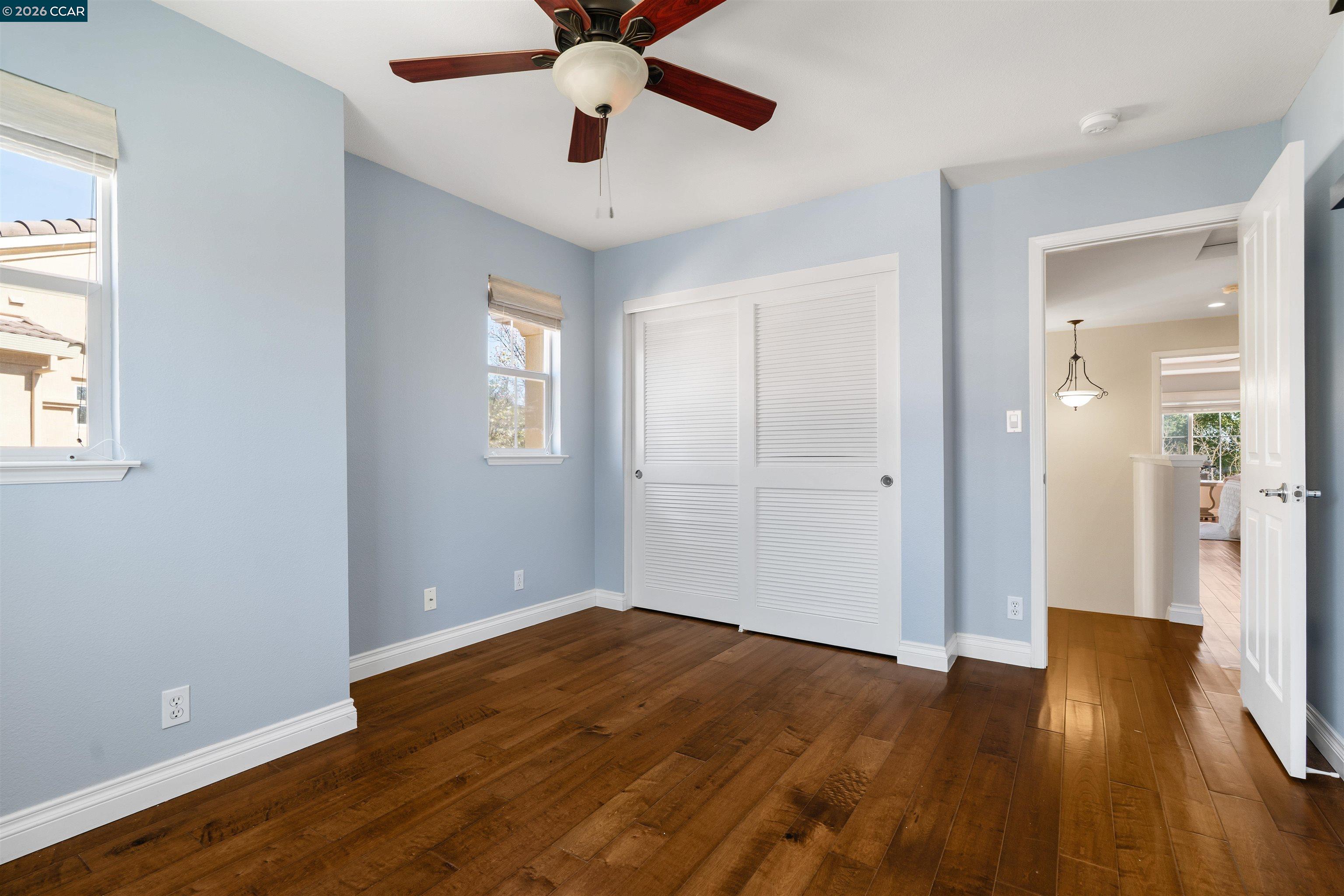 7151 Briza Loop San Ramon, CA 94582 - Photo 19 of 29 an empty room with wooden floor and windows