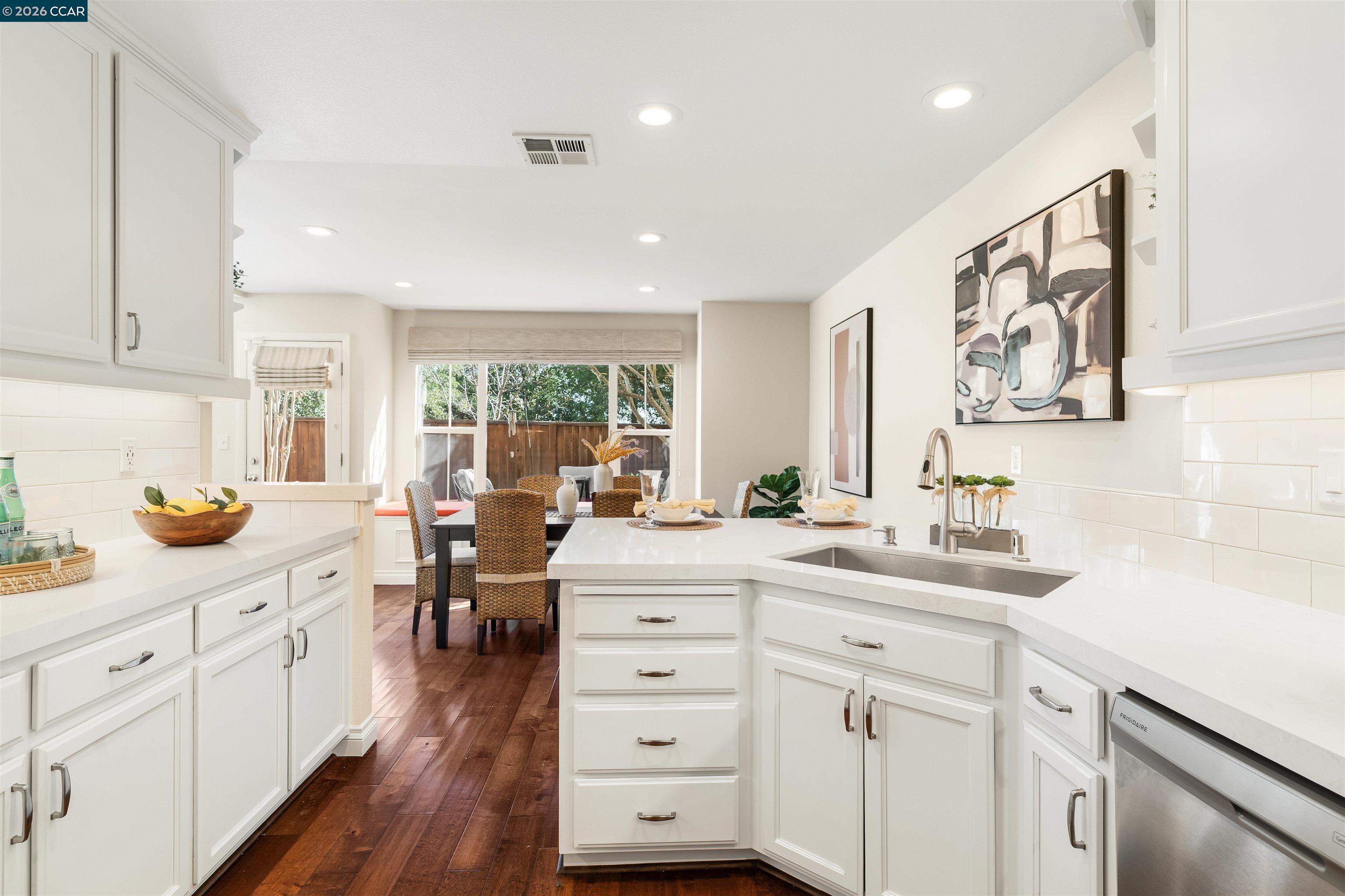 7151 Briza Loop San Ramon, CA 94582 - Photo 10 of 29 a kitchen with white cabinets and wooden floors