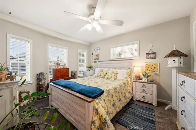 a bedroom with a bed and large windows