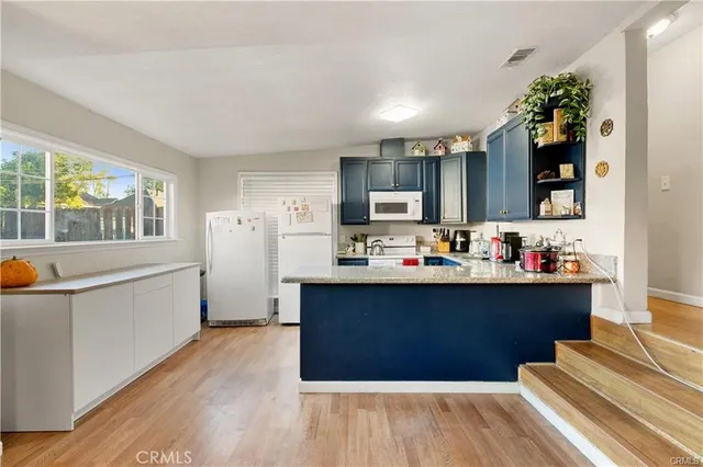 a kitchen with a sink refrigerator and microwave