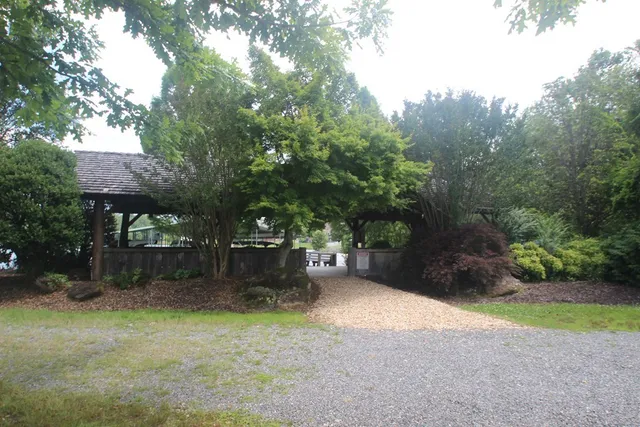 a backyard of a house with a trees and swing