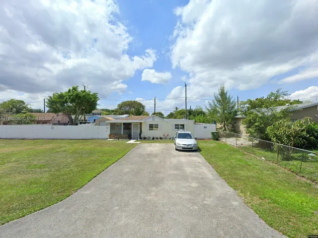 a view of a house with garden and a yard