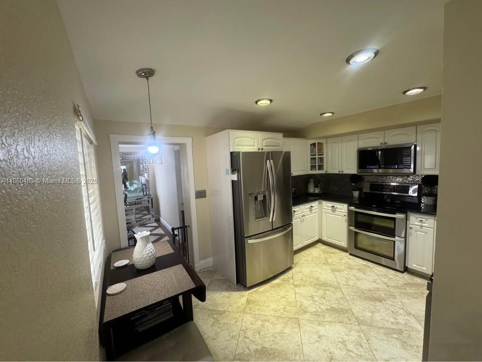3781 Riedel Avenue Palm Springs, FL 33461 - Photo 6 of 21 a kitchen with stainless steel appliances kitchen island granite countertop a refrigerator and a sink