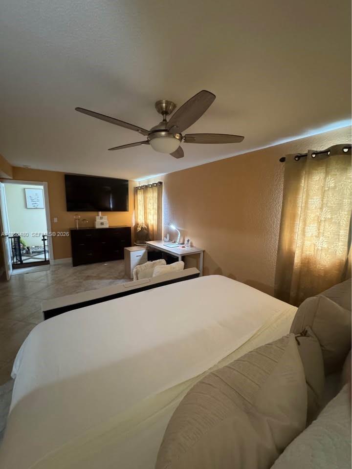 3781 Riedel Avenue Palm Springs, FL 33461 - Photo 8 of 25 a large white bed in a kitchen and a flat screen tv