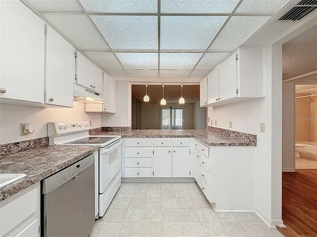 a kitchen with granite countertop a sink a stove and cabinets