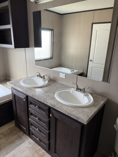 20410 Telge Road, Unit 11 Tomball, TX 77377 - Photo 21 of 30 a bathroom with a granite countertop sink and a mirror