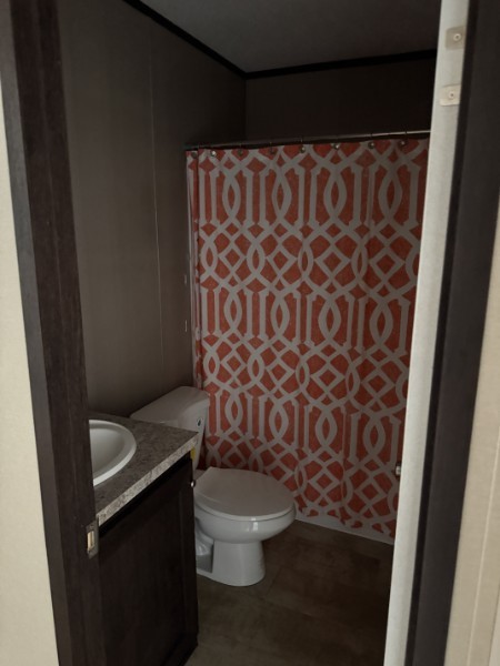 20410 Telge Road, Unit 11 Tomball, TX 77377 - Photo 29 of 30 a white toilet sitting next to a shower curtain