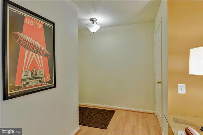 12009 Golf Ridge Court, Unit 202 Fairfax, VA 22033 - Photo 2 of 30 a view of a hallway with paintings on the wall