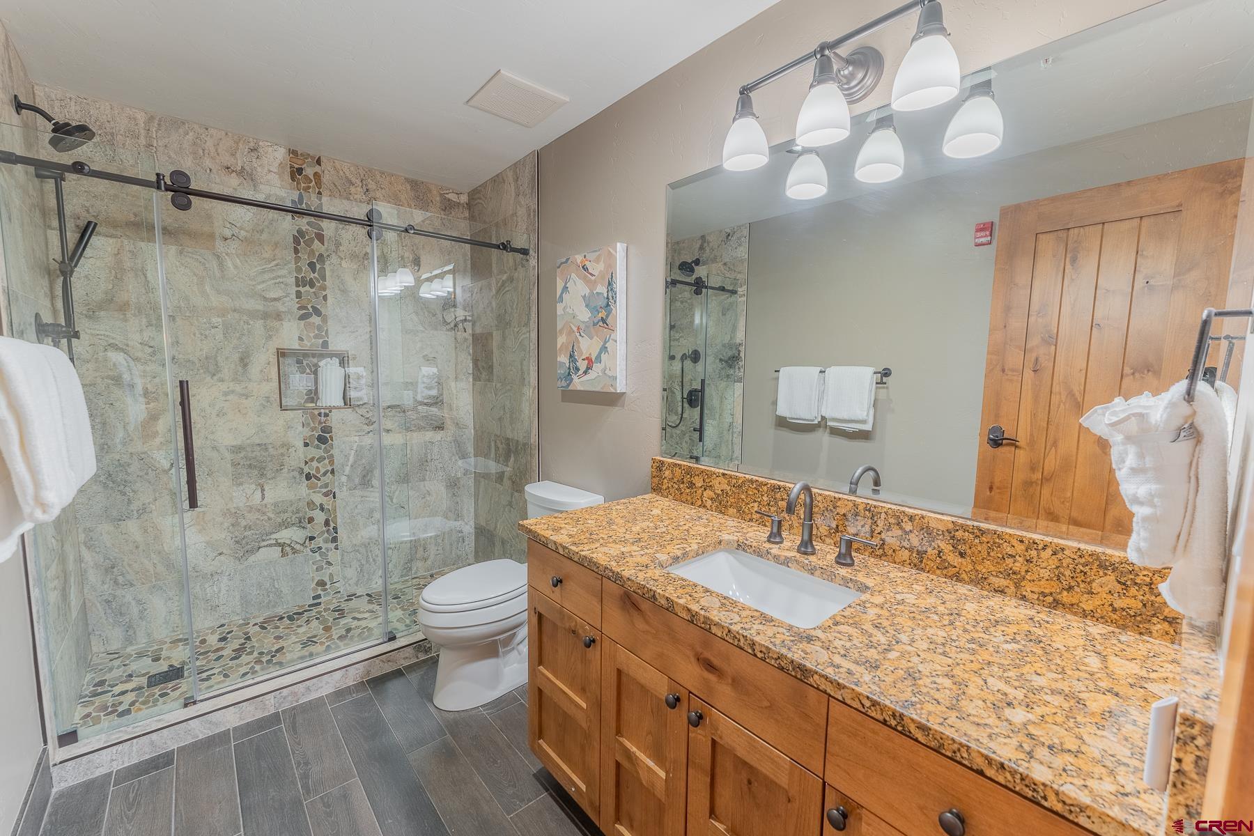 14 Hunter Hill Road, Unit A208 Crested Butte, CO 81225 - Photo 14 of 35 a bathroom with a granite countertop sink a toilet a mirror and shower