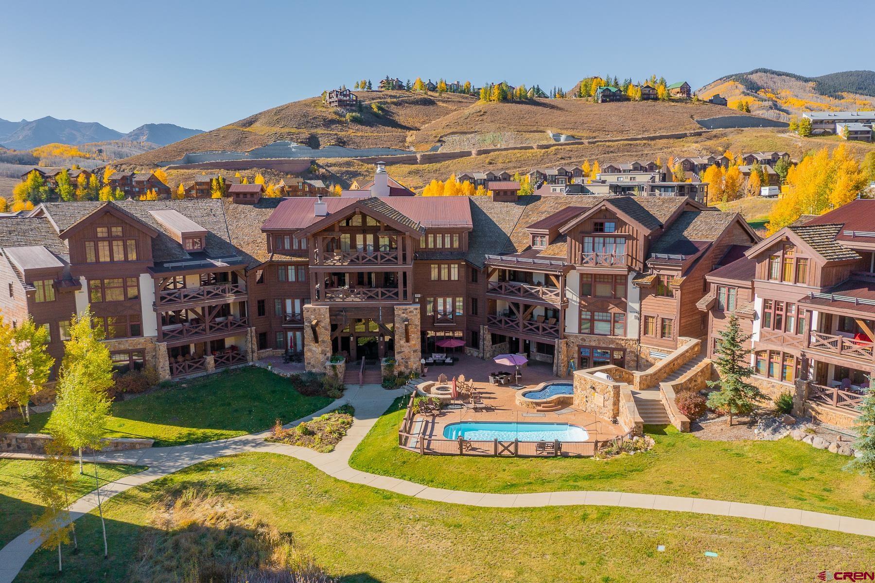 14 Hunter Hill Road, Unit A208 Crested Butte, CO 81225 - Photo 22 of 35 a view of a house with a big yard and dining table and chairs