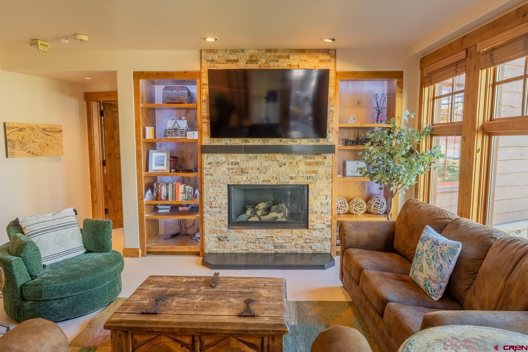 14 Hunter Hill Road, Unit A208 Crested Butte, CO 81225 - Photo 26 of 35 a living room with furniture a flat screen tv and a fireplace