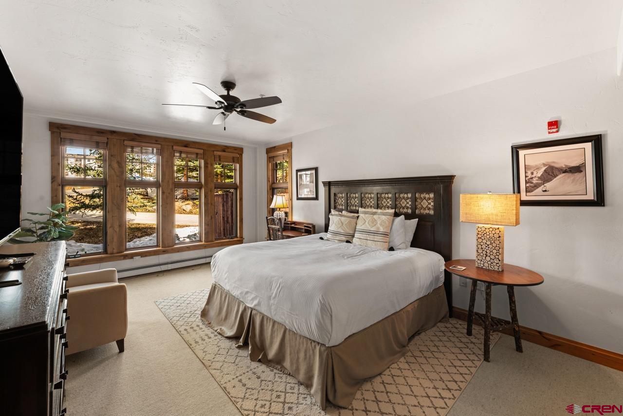 14 Hunter Hill Road, Unit A208 Crested Butte, CO 81225 - Photo 29 of 43 a bedroom with a large bed a flat tv screen and a dresser