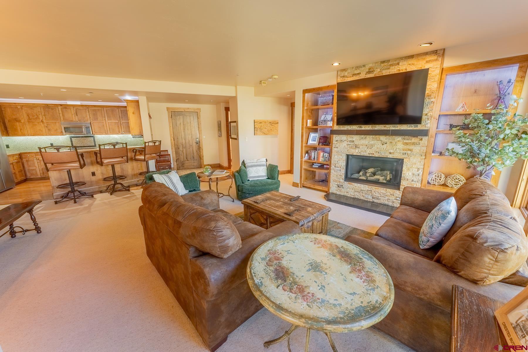 14 Hunter Hill Road, Unit A208 Crested Butte, CO 81225 - Photo 3 of 35 a living room with fireplace furniture and a flat screen tv