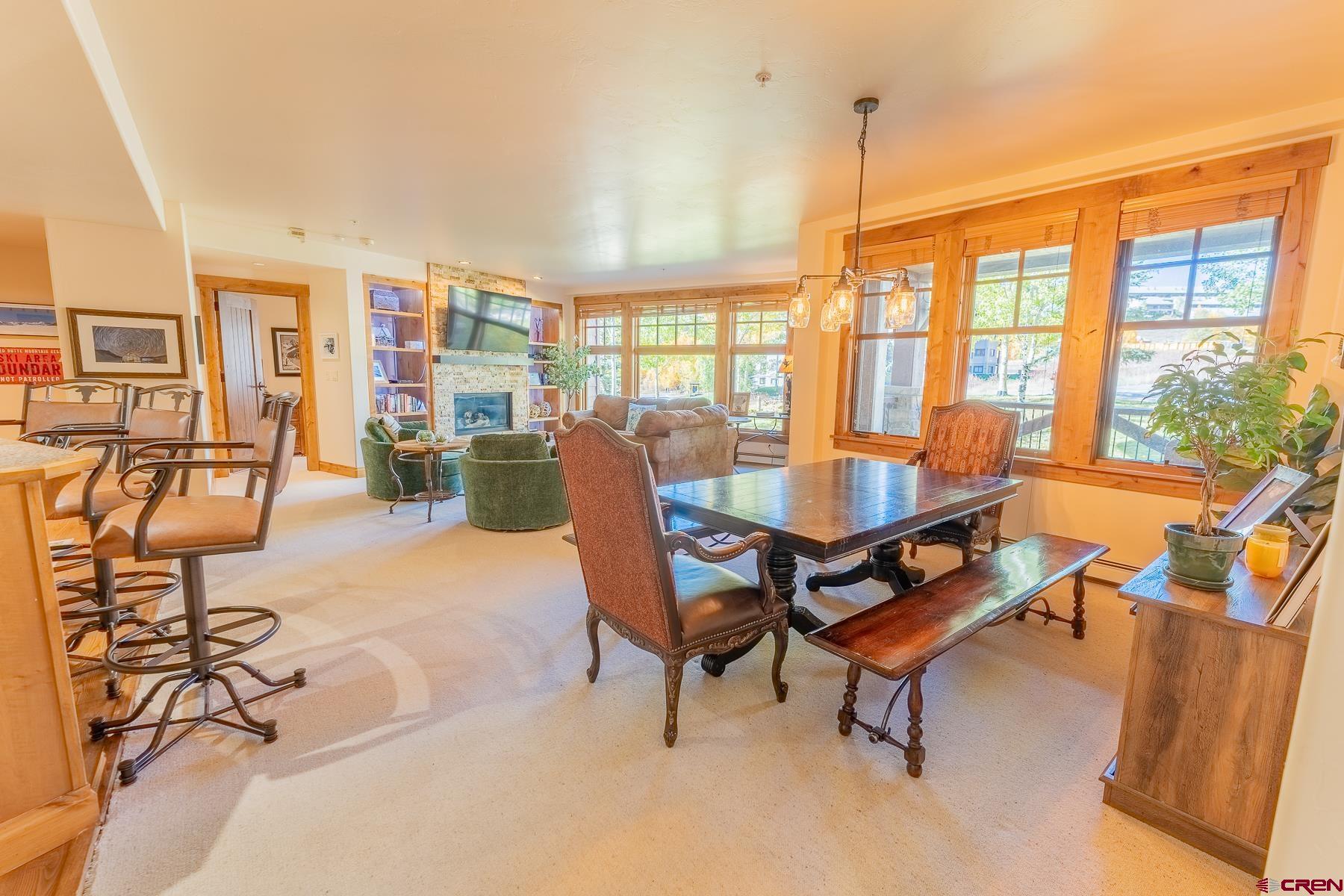 14 Hunter Hill Road, Unit A208 Crested Butte, CO 81225 - Photo 5 of 35 a dining room with furniture water view and large windows