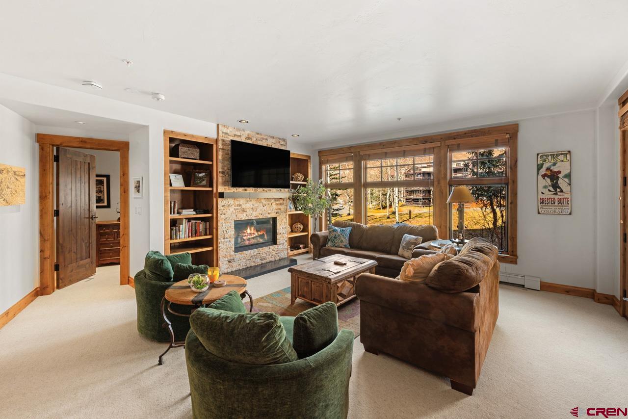 14 Hunter Hill Road, Unit A208 Crested Butte, CO 81225 - Photo 10 of 43 a living room with furniture a flat screen tv and a fireplace