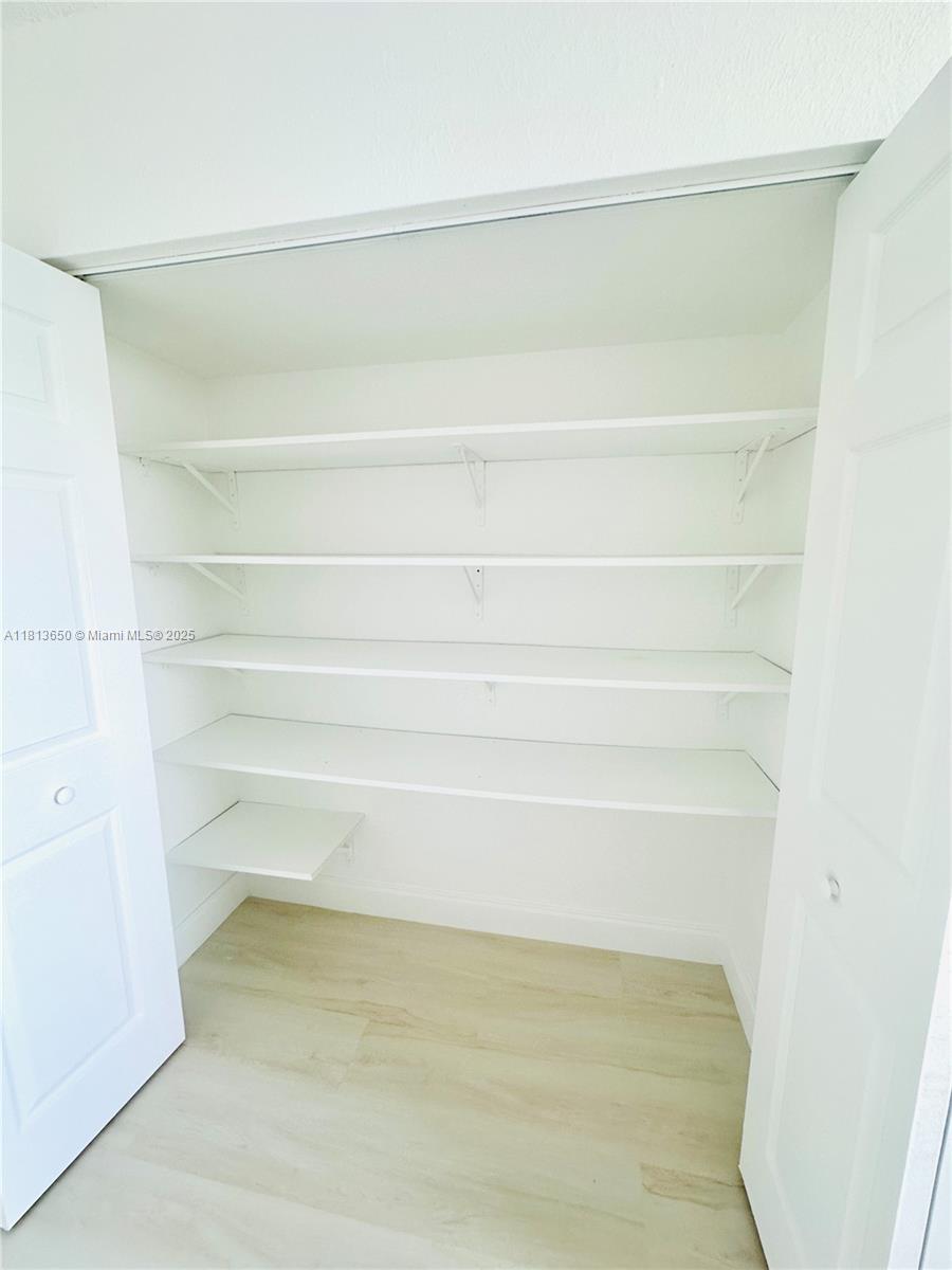 9001 Southwest 77th Avenue, Unit C608 Miami, FL 33156 - Photo 9 of 15 a view of a closet with racks on the wall