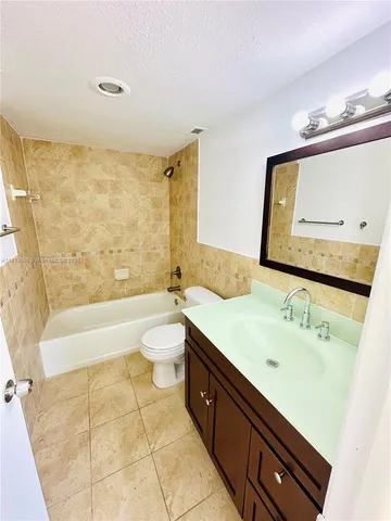 a spacious bathroom with a double vanity sink toilet mirror and bathtub