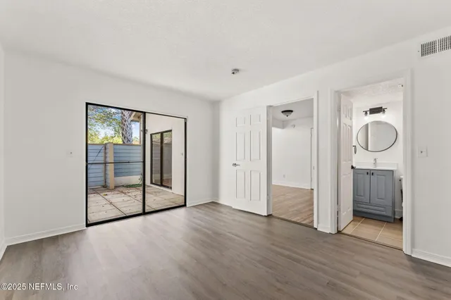 a view of a livingroom with wooden floor and sliding door