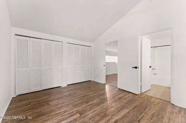 a view of an empty room with wooden floor