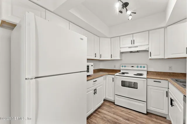 a kitchen with a white cabinets and white appliances