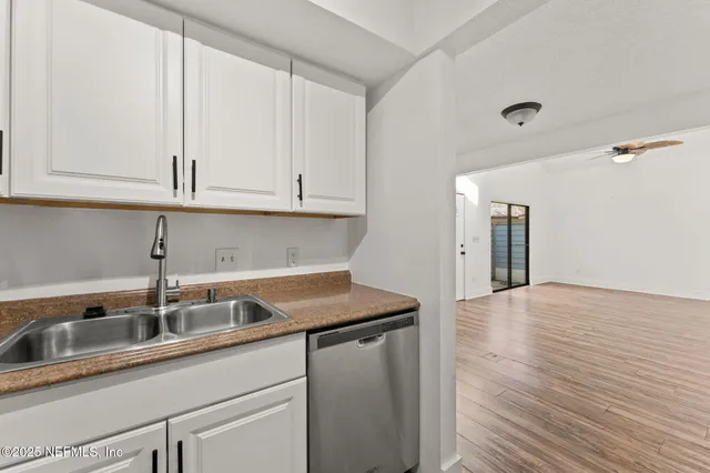 a kitchen with stainless steel appliances granite countertop a sink and cabinets with wooden floors