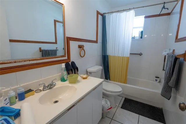 a bathroom with a sink a toilet and shower curtain