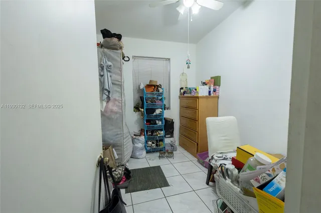 a living room with a couch and a potted plant on th wall