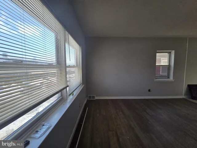 an empty room with wooden floor and closet