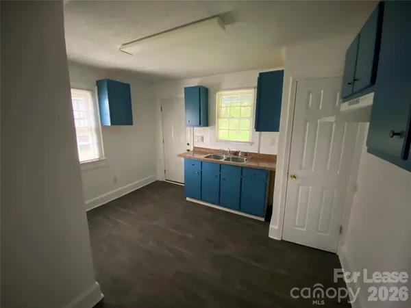 a view of kitchen with granite countertop cabinets and sink