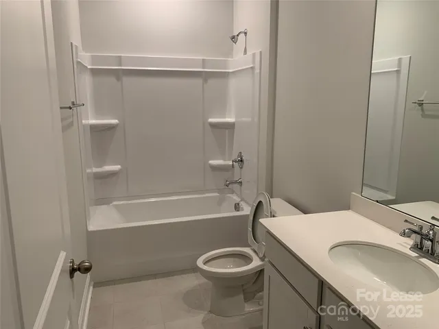 a bathroom with a granite countertop sink toilet tub and shower