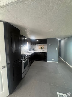 8155 South Redwood Road, Unit 96 West Jordan, UT 84088 - Photo 8 of 17 Kitchen featuring dark cabinetry, gas range, and light countertops