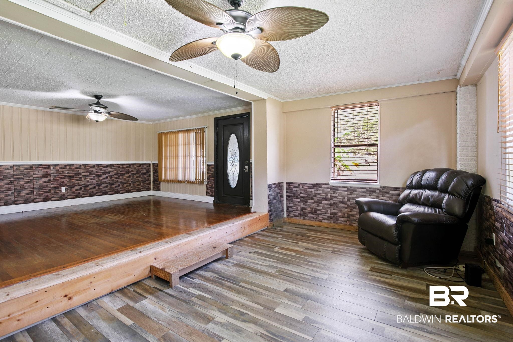 23240 County Road 47 Perdido, AL 36562 - Photo 8 of 29 Living room with wood-type flooring, wainscoting, crown molding, a textured ceiling, and a ceiling fan