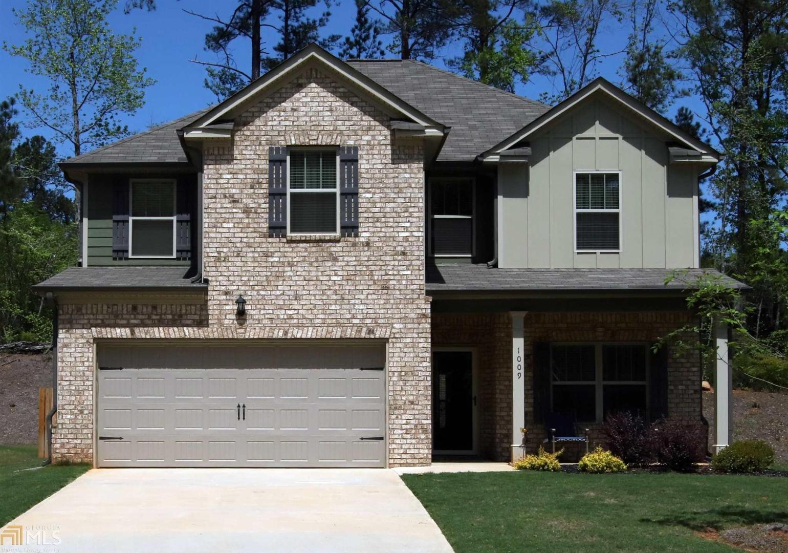 1009 Hartwell Road, Unit 3 Locust Grove, GA 30248 - Photo 1 of 1 a front view of a house with a yard and garage