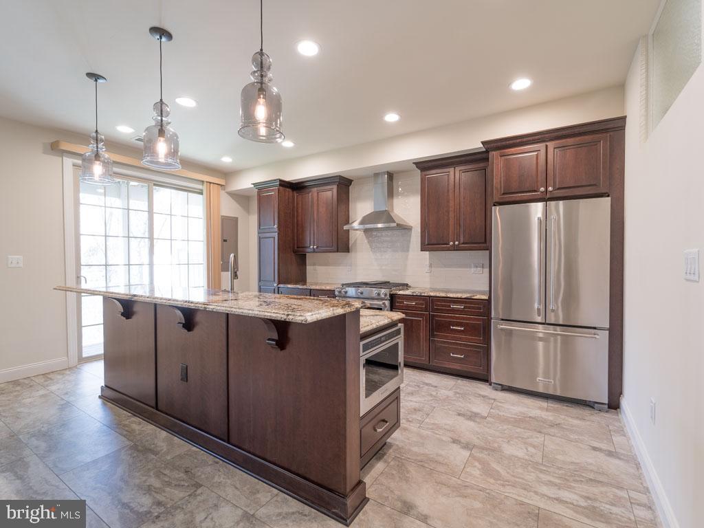 22595 Windsor Locks Square Ashburn, VA 20148 - Photo 7 of 56 a open kitchen with stainless steel appliances granite countertop a refrigerator a sink dishwasher a oven and a refrigerator with wooden floor