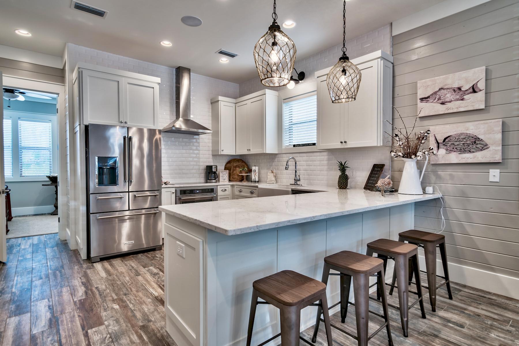33 West Seacrest Beach Blvd Inlet Beach Inlet Beach, FL 32461 - Photo 3 of 53 a kitchen with stainless steel appliances granite countertop a refrigerator a sink dishwasher a stove and white cabinets with wooden floor