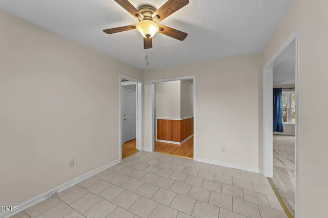 an empty room with closet and a chandelier fan