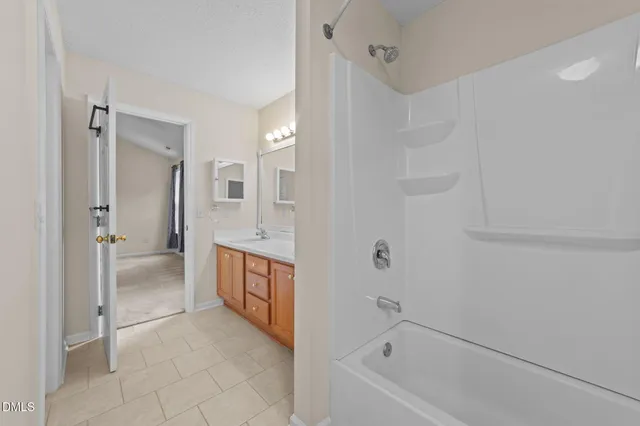 a spacious bathroom with a tub sink and mirror