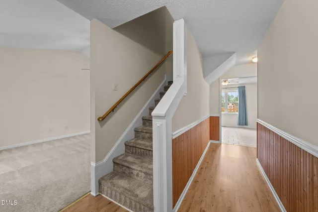 a view of a hallway with wooden floor and staircase