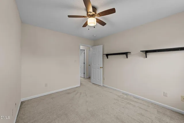 an empty room with a ceiling fan and a fan