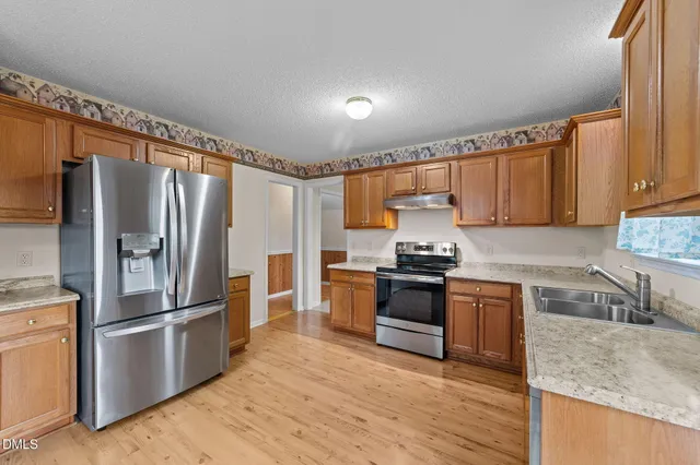 a kitchen with granite countertop stainless steel appliances and wooden cabinets