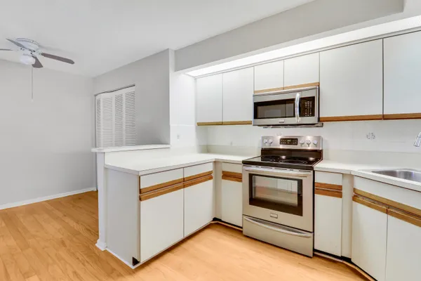 a kitchen with white cabinets and stainless steel appliances