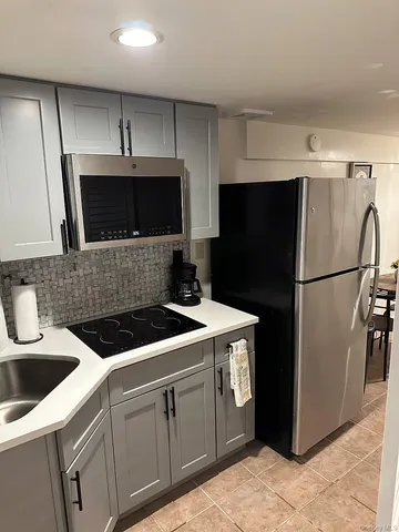 a kitchen with stainless steel appliances a refrigerator a sink a stove a microwave a sink and cabinets