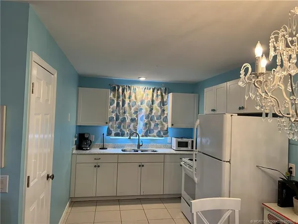 a kitchen with a refrigerator sink and cabinets